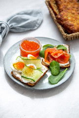 Smorrebrod - danish open sandwich with red caviar, fish, vegetables, cheese on marble background. Top view with copy space