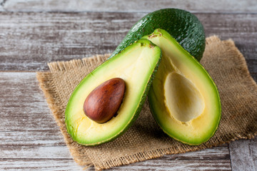 Close-up of an avocado and avocado oil on wooden table. Healthy food concept.