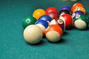 Old billiard balls composition on green pool table