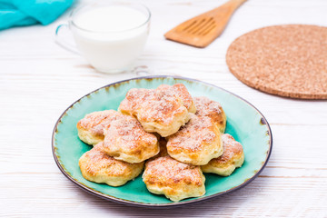 Ready-to-eat cottage cheese cookies on a plate on a wooden table.