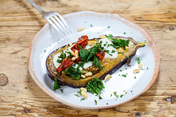 Roast aubergine with goat cheese, sun dried tomatoes, crispy kale and pine nuts