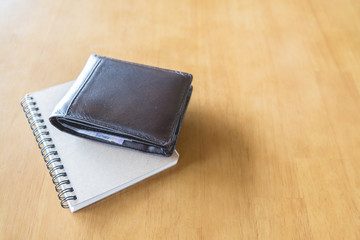 Brown wallet and book on table, copy space, background