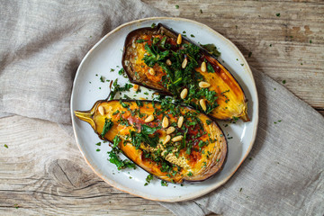 Roast aubergine with goat cheese, sun dried tomatoes, crispy kale and pine nuts