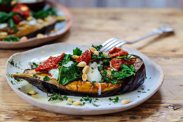 Roast aubergine with goat cheese, sun dried tomatoes, crispy kale and pine nuts