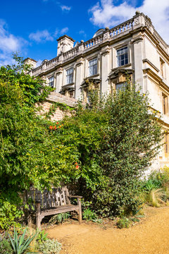 Park bench in Scholars' Garden on a beautiful sunny day at Clare College, University of Cambridge, England