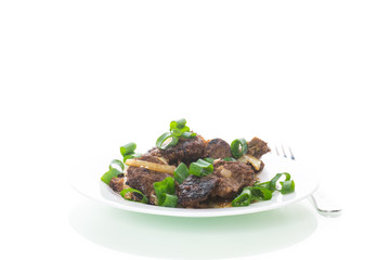 fried liver with onions in a plate on a white