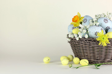 Cestino con le Uova di Pasqua e fiori su uno sfondo chiaro