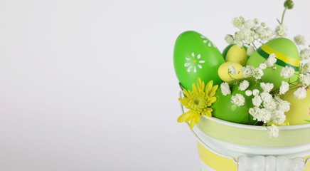 Cestino con le Uova di Pasqua e fiori su uno sfondo chiaro