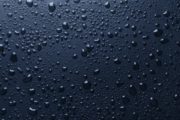 Blue surface with shiny water drops, background