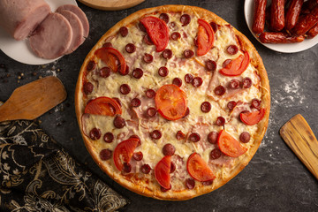 Pizza with ham and smoked sausages for a restaurant menu.
