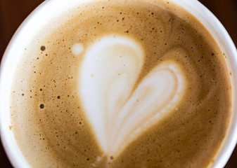Foam on coffee close-up. Foam in the shape of heart background