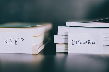 selecting which books to keep and which to discard or donate, decluttering concept