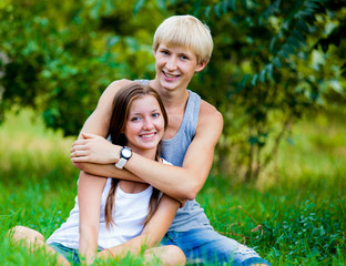 Young teenage couple in green park.