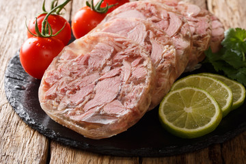 Cheese head or brawn with fresh tomatoes, lime and cilantro close up on the table. horizontal
