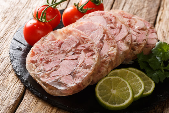 Homemade head cheese or brawn with fresh tomatoes, lime and cilantro close up. horizontal
