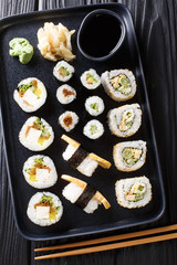 Delicious Japanese sushi rolls large set with seafood, vegetables, tofu and tamago closeup. Vertical top view