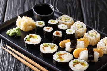Delicious Japanese sushi rolls large set with seafood, vegetables, tofu and tamago closeup. horizontal