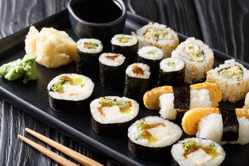 Japanese rolls set with tuna, tofu, charred, avocado, tamago closeup on a plate. horizontal