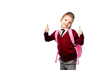 Back to school. Beautiful little girl dressed like a School girl - in white shirt, red blouse and gray pants hold a school bag and posing like model - show thumb up. Isolated on white.