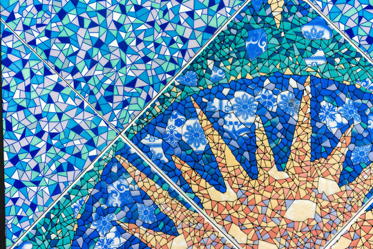 Blue ceramic mosaic tile with the image of the sun. Background and texture of ceramic tiles.