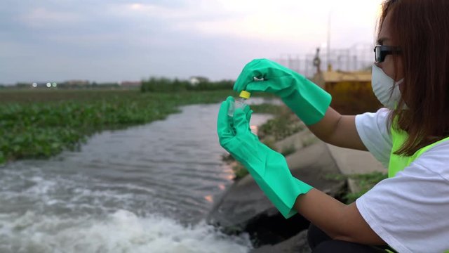 Asian woman Scientist experimenting with water quality at wastewater treatment system,Thailand people