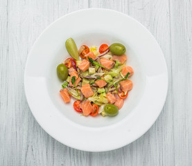 Pasta salad with smoked salmon, olives, cherry tomatoes, pink pepper and fresh basil. Home made food. Symbolic image.