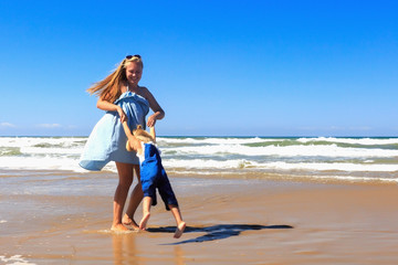 Mother and daughter have fun on the beach.