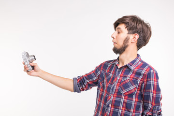 Technology, photography and people concept - Handsome man in plaid shirt taking a selfies on vintage camera