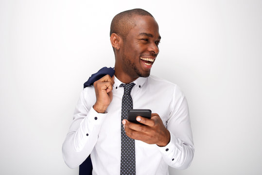 happy black businessman holding mobile phone and laughing