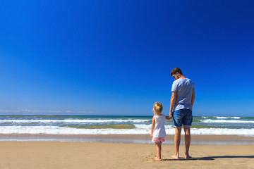 Fototapeta na wymiar Father and daughter have fun on the seashore.