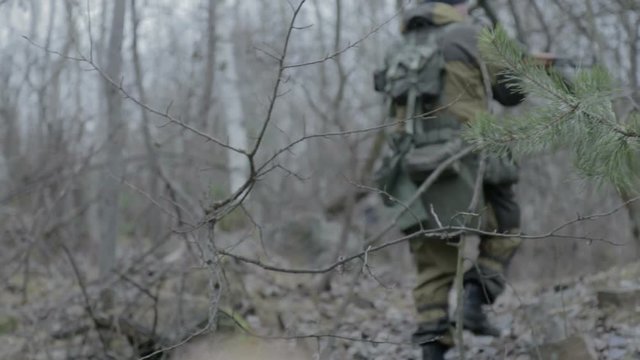 A group of scout saboteurs perform the task. An armed soldier without identification chevrons belonging to the army, terrorist, saboteur.