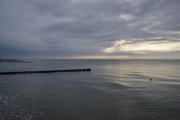 Obraz premium Wellenbrecher, Ostsee, Meer, Nordsee, Wellen, Hintergrund, Natur, Blau, Windig, Sonne, Urlaub, Erholung, Sonnenuntergang, Himmel