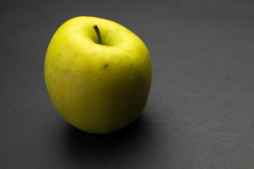 Yellow apple on a dark background