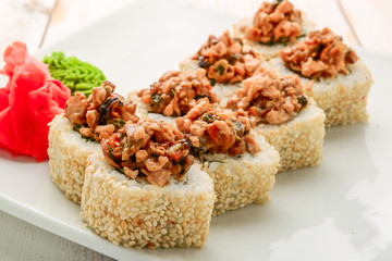 Japanese sushi roll topped with spicy salmon slice