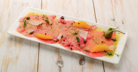 Restaurant Starter Menu with Slightly Salted Salmon Fillet Isolated on White Background. Thin Slices of Red Fish or Trout with Lemon and Greens o
