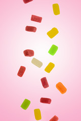 Caramel candy falling on a pink background, sweets and delicacies
