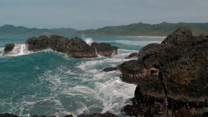 Slow motion shot of big sea waves crashing against the rocks. Waves crashing and hitting on the rocks at the sea. Palawan island, Philippines. Beautiful scenic nature landscape. S Travel concept.