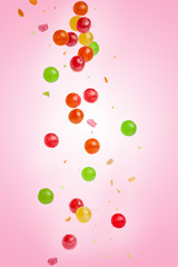Falling colored candy, sweets. On a pink background