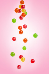 Caramel candy falling on a pink background, sweets and delicacies