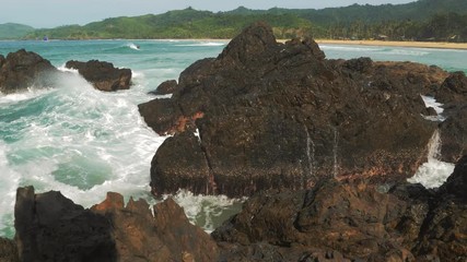 Slow motion shot of big sea waves crashing against the rocks. Waves crashing and hitting on the rocks at the sea. Palawan island, Philippines. Beautiful scenic nature landscape. S Travel concept.