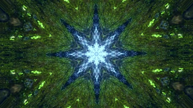 Video con forma de mandala girando y cambiando formas con formas de estrellas y &aacute;ngulos que se abren en las figuras formadas con caleidoscopio con movimiento en colores verdes y azules