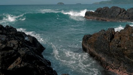 Slow motion shot of big sea waves crashing against the rocks. Waves crashing and hitting on the rocks at the sea. Palawan island, Philippines. Beautiful scenic nature landscape. S Travel concept.