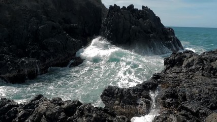 Slow motion shot of big sea waves crashing against the rocks. Waves crashing and hitting on the rocks at the sea. Palawan island, Philippines. Beautiful scenic nature landscape. S Travel concept.