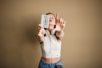 Young hipster woman with white retro audio cassette. Party 90s concept.