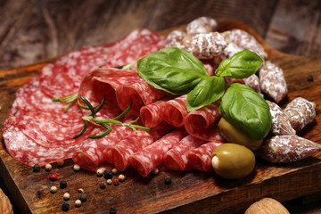 thinly sliced salami on a wooden texture on the background.