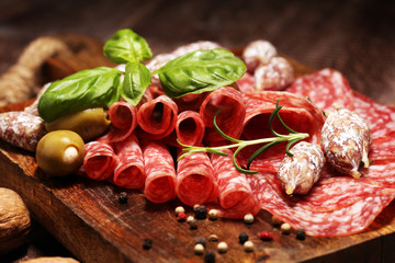 thinly sliced salami on a wooden texture on the background.