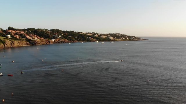 Aerial shot at sunset of a boat at Solanas beach in Punta del Este
