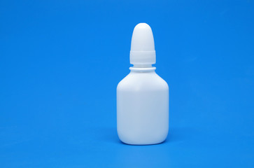Nasal spray and dropper isolated on blue background.
