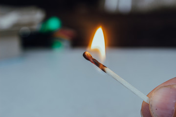 a lit match on a light background