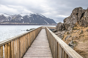 Wooden pedestrian walkway around a cliff at the bank of a fjord near the town of Borgarnes, Iceland